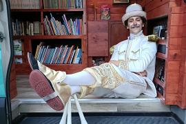 Homem mascarado com roupa branca e dourada, chapeu e três malabares